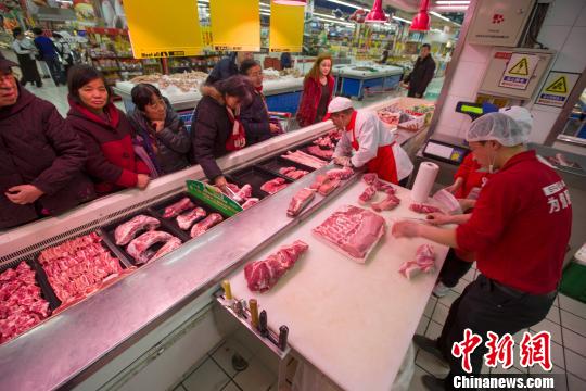 山西太原，超市员工在为民众分解<a href=http://www.chuhe.com/_quanweishuju/zhurou/zhuroujiage/ target=_blank class=infotextkey>猪肉</a>。张云 摄