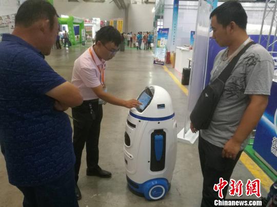 图为参展商与客商就智能农业机器人进行沟通交流。　孙亭文 摄