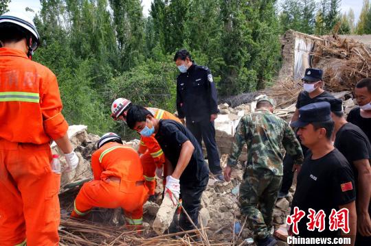 8月12日，在精河县托里镇地震灾区，公安民警和消防官兵正在坍塌的房屋中搜寻、转移灾民财产。　田向东　摄