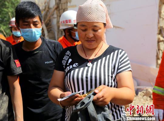 公安民警帮助兰某在坍塌的房屋中搜寻到金项链。　田向东 摄